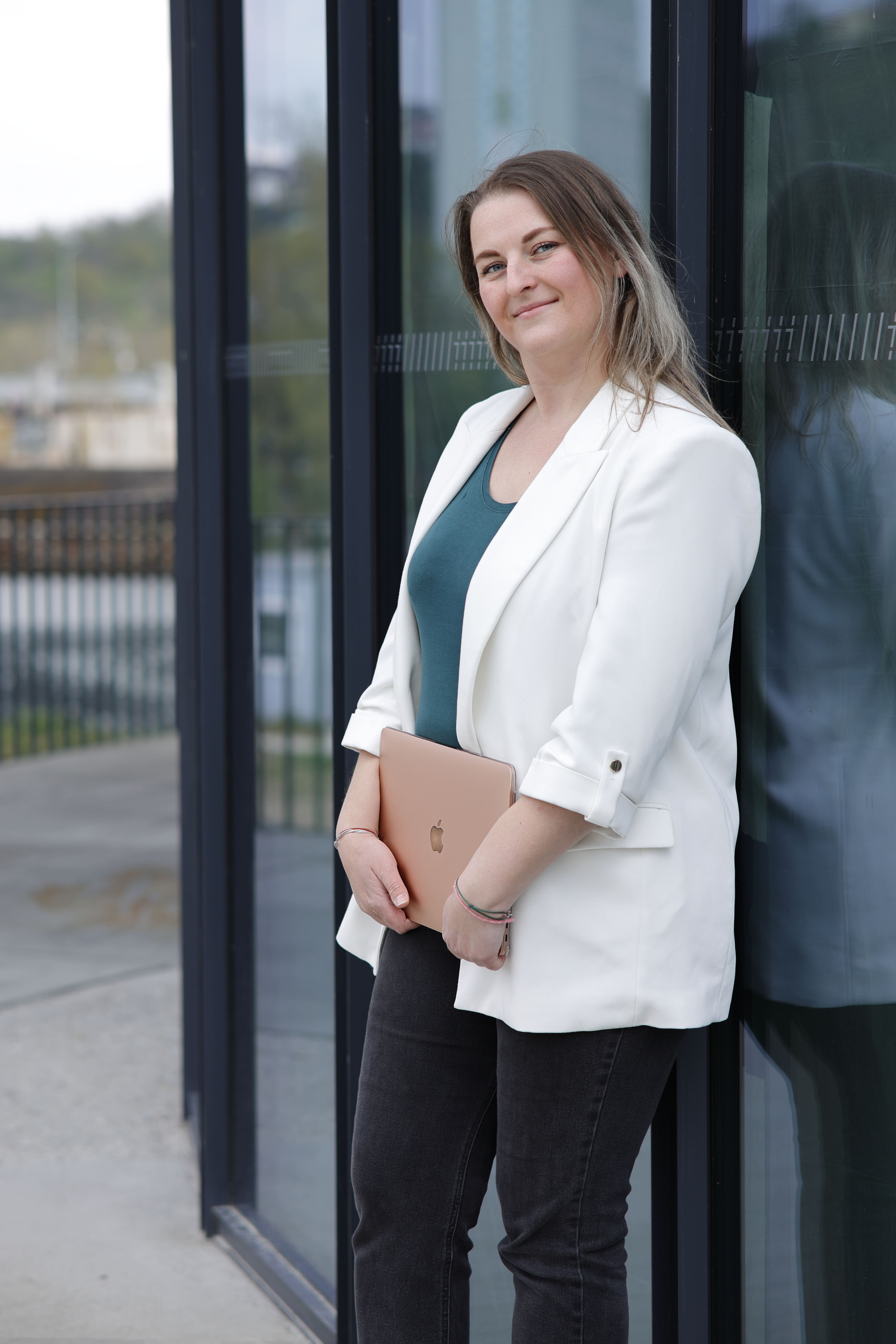 Lucie Mertová se usmívá a drží notebook